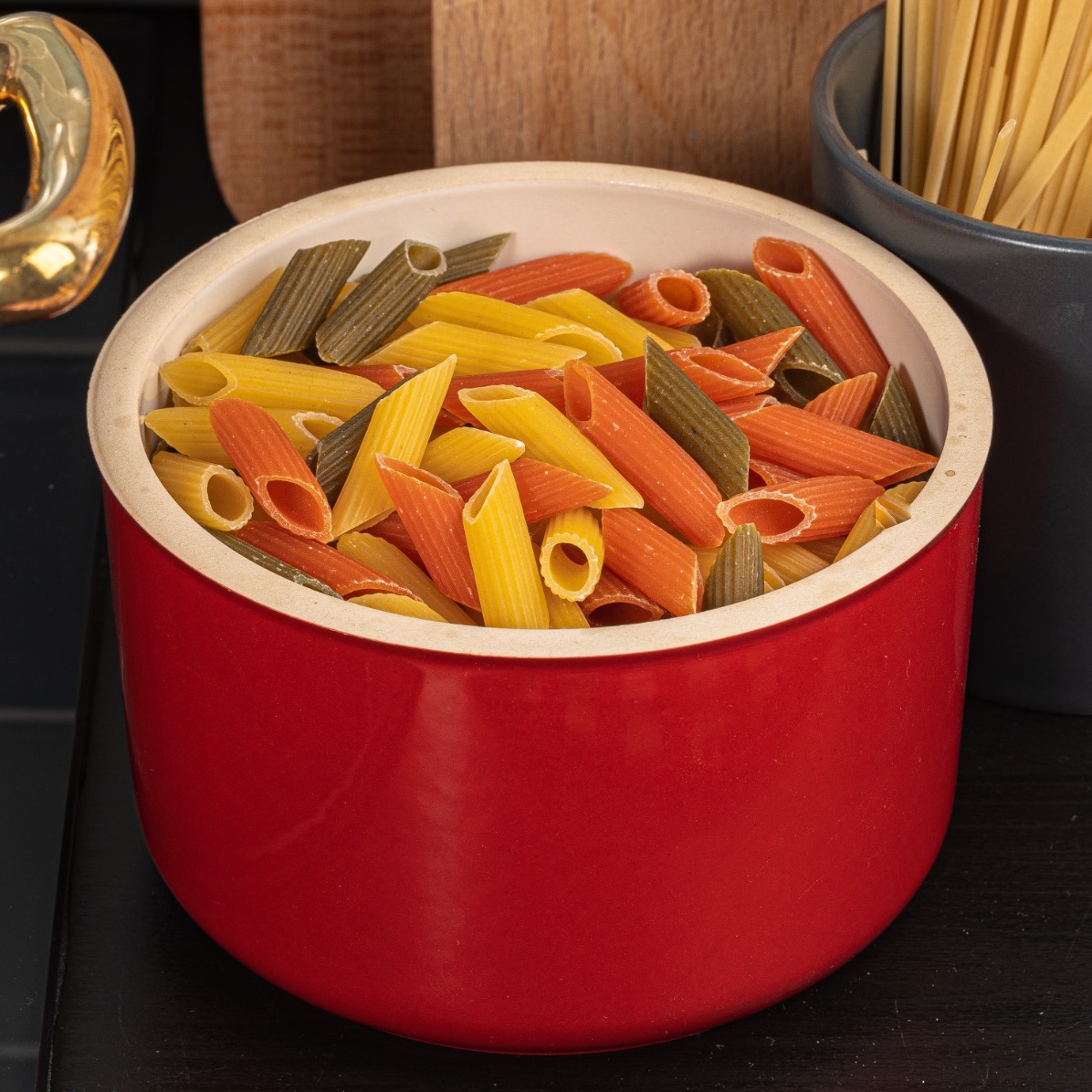 Colorful penne pasta in a red pot