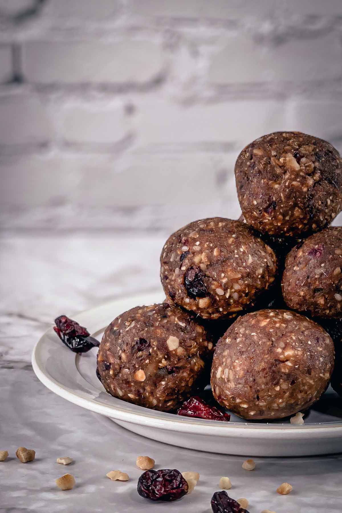 Energy bites with dates stacked on a white plate